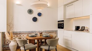 A modern dining area with a round table, chairs, and a decorative vase. - Ando Living - Santa Justa 79 House - 301 (Lisboa)