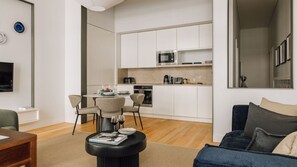 Un appartement moderne comprenant un coin repas, une cuisine et un salon.