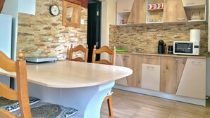 Una cocina moderna con una mesa de comedor, sillas, un reloj y armarios de madera.
