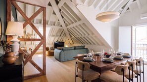 A dining area with a wooden table, chairs, and a ceiling with exposed beams.