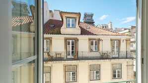 En traditionel bygning i europæisk stil med tegltag, mange vinduer og en balkon med gelænder.