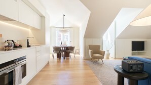 Eine moderne Küche mit Essbereich, eine Sitzecke mit Fernseher und ein Schlafgeschoss mit Fenster.
