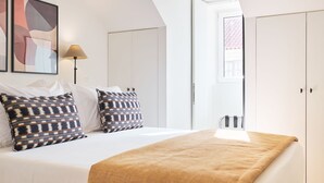 Ein Schlafzimmer mit Bett, Kissen, einer Lampe und einem Kleiderschrank.