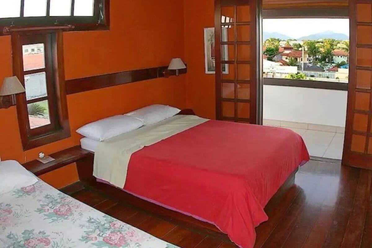 A bedroom with a bed, a window, and a view of the outside.