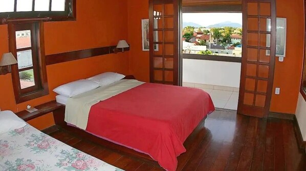 A bedroom with a bed, a window, and a view of the outside.