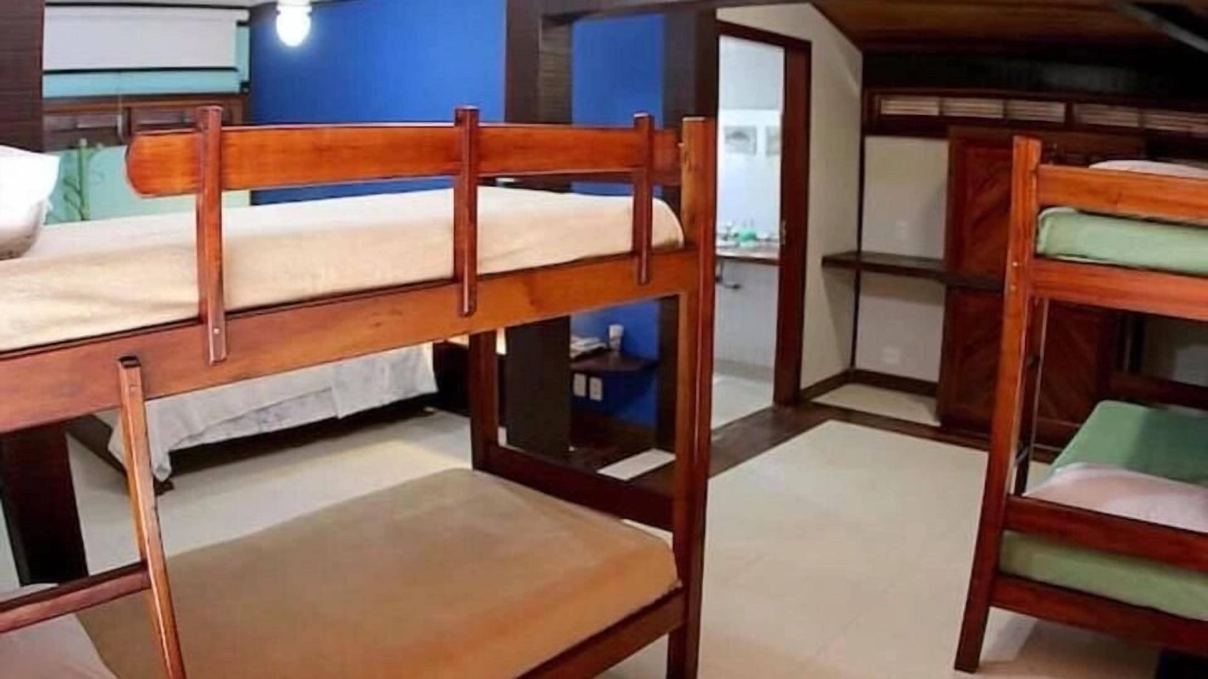 Een slaapkamer met een stapelbed met houten frames en een klein bureau.