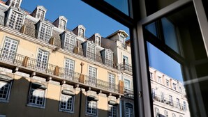 Um edifício com várias andares, varandas e janelas, visto de dentro de outro edifício.