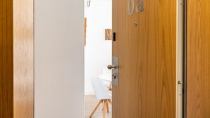 Eine Holztür mit einem Zahlenschloss und einem Klingelknopf.