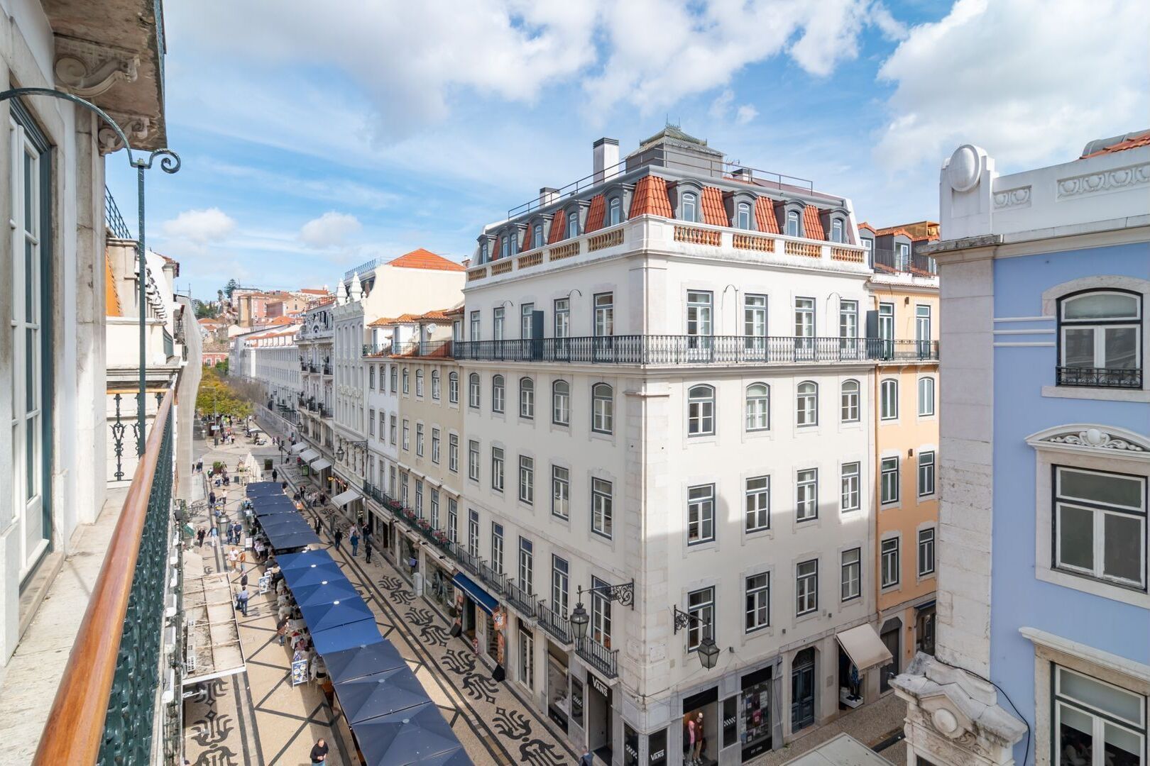 A multi-story building with a traditional architectural style, featuring balconies and a tiled roof.