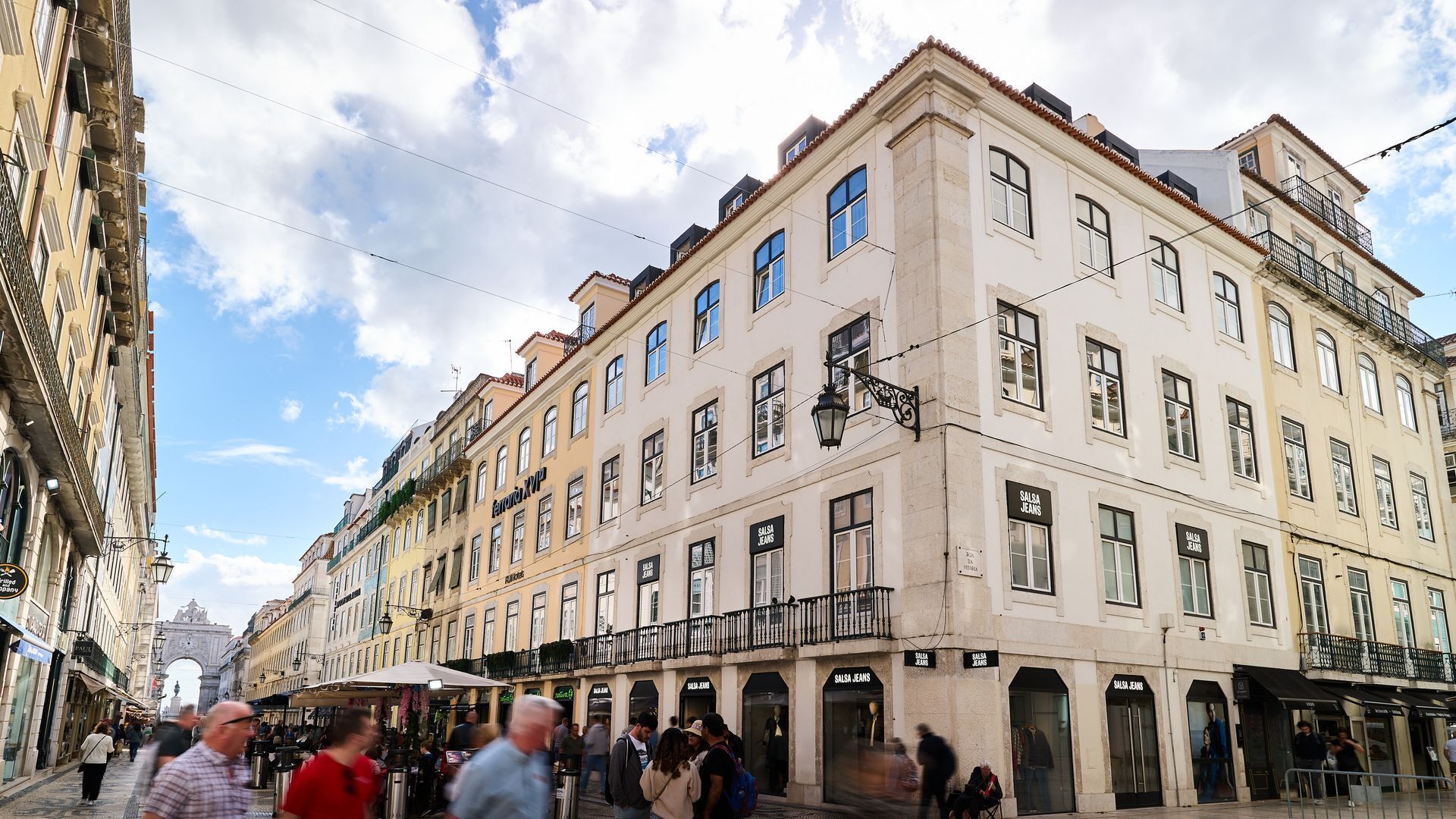 Un bâtiment historique abritant plusieurs boutiques, dont une boutique « Salsa Jeans » bien en vue.