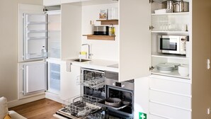 Una cucina funzionale con frigorifero Bosch, lavastoviglie integrata, microonde e lavello.