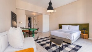 Una habitación de hotel con cama, escritorio, silla, mesa y lámpara colgante.