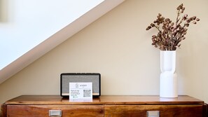 A wooden dresser with a vintage radio and a white vase with dried flowers. - Ando Living - Augusta House - 401 (Lisboa)