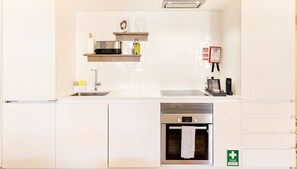 Een moderne keuken met witte kasten, een Bosch oven en een spoelbak.