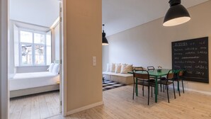 A modern interior with a dining area, a seating bench, and a chalkboard with writing. - Carmo 43 | Apartamento 104 (Lisboa)