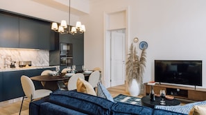 Una sala de estar moderna con comedor, cocina y televisor.