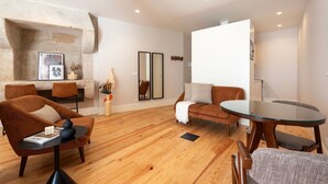 Een moderne woonkamer met een stenen open haard, houten vloer en eigentijds meubilair.