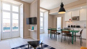 En moderne lejlighed med spiseplads, køkken og balkon med udsigt.
