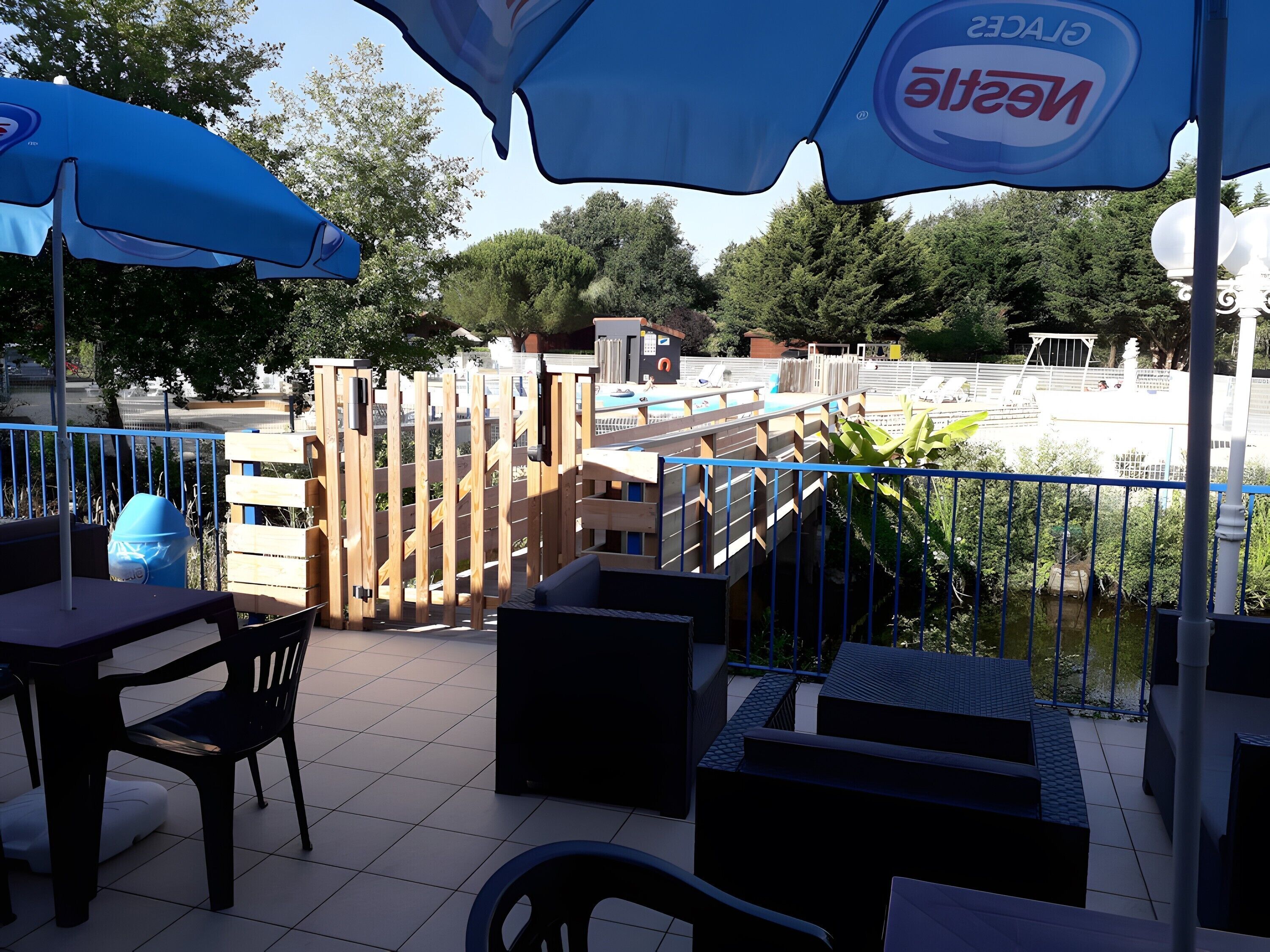 En terrasse med udendørs siddepladser, en pool og udsigt over det omkringliggende område.