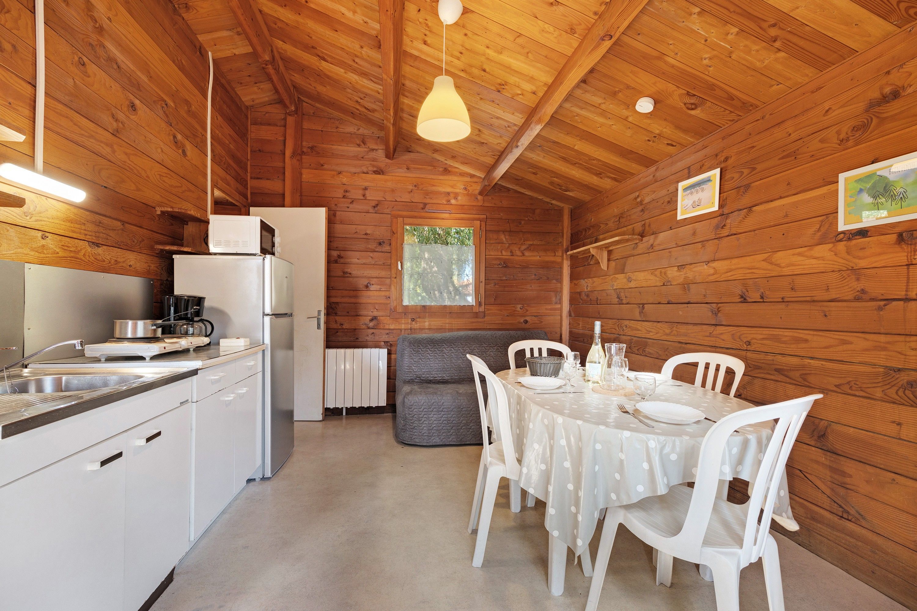 Ein Holzblockhaus-Innenraum mit Küche, Essbereich und einem Fenster.