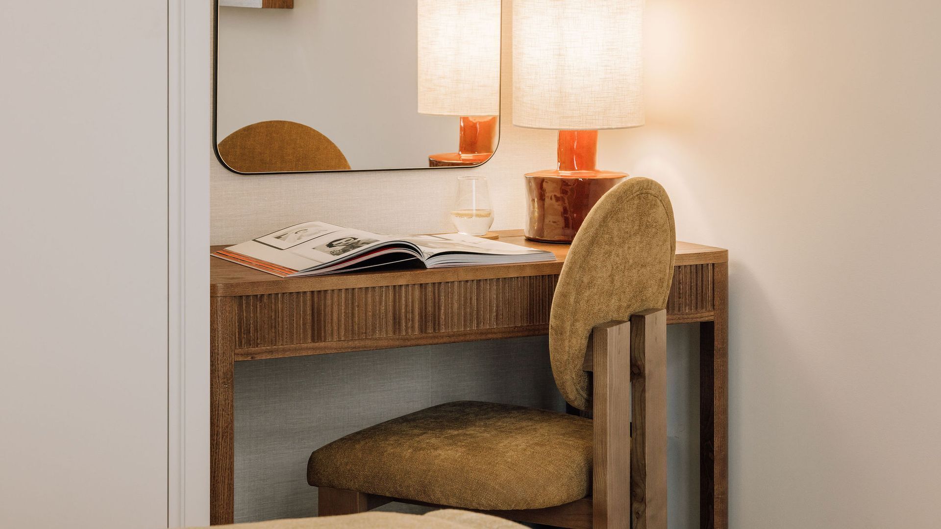 Un bureau en bois, une chaise, une lampe et un magazine.