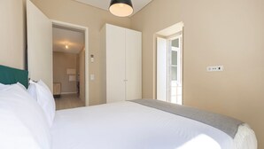 Una camera da letto con un letto, un armadio, una porta e un lampadario.
