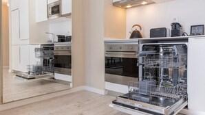 Una cucina moderna con elettrodomestici integrati, tra cui lavastoviglie, forno e microonde.