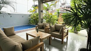 A patio area with a pool, outdoor furniture, and lush greenery. - PRIIMA (Ahangama)