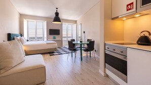 Eine moderne Wohnung mit einem Bett, einem Esstisch und einer Küchenzeile.