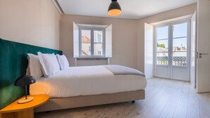 Una camera da letto con un letto, un comodino, una lampada, una finestra e una porta.