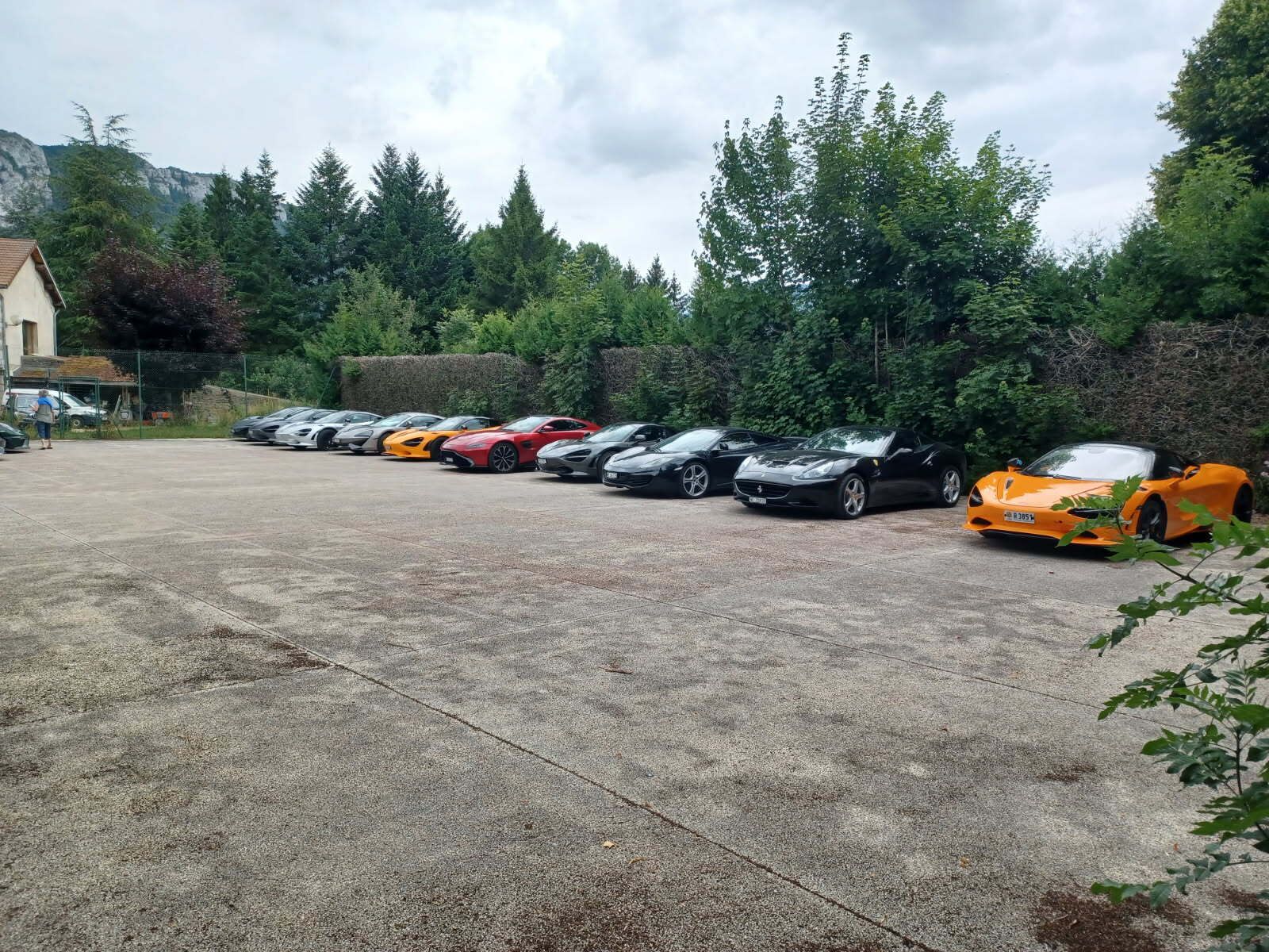 Un estacionamiento con varios autos deportivos alineados.
