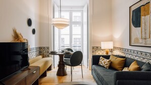 Un salon moderne avec un canapé, une table à manger et un téléviseur.