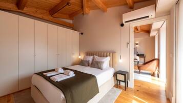 Un dormitorio con cama, mesitas de noche, un armario y vistas a otra habitación.