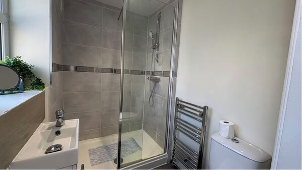 A bathroom with a glass-enclosed shower, a sink, and a toilet. - Warm and Cosy Two bed Property /Near York City Centre (York)