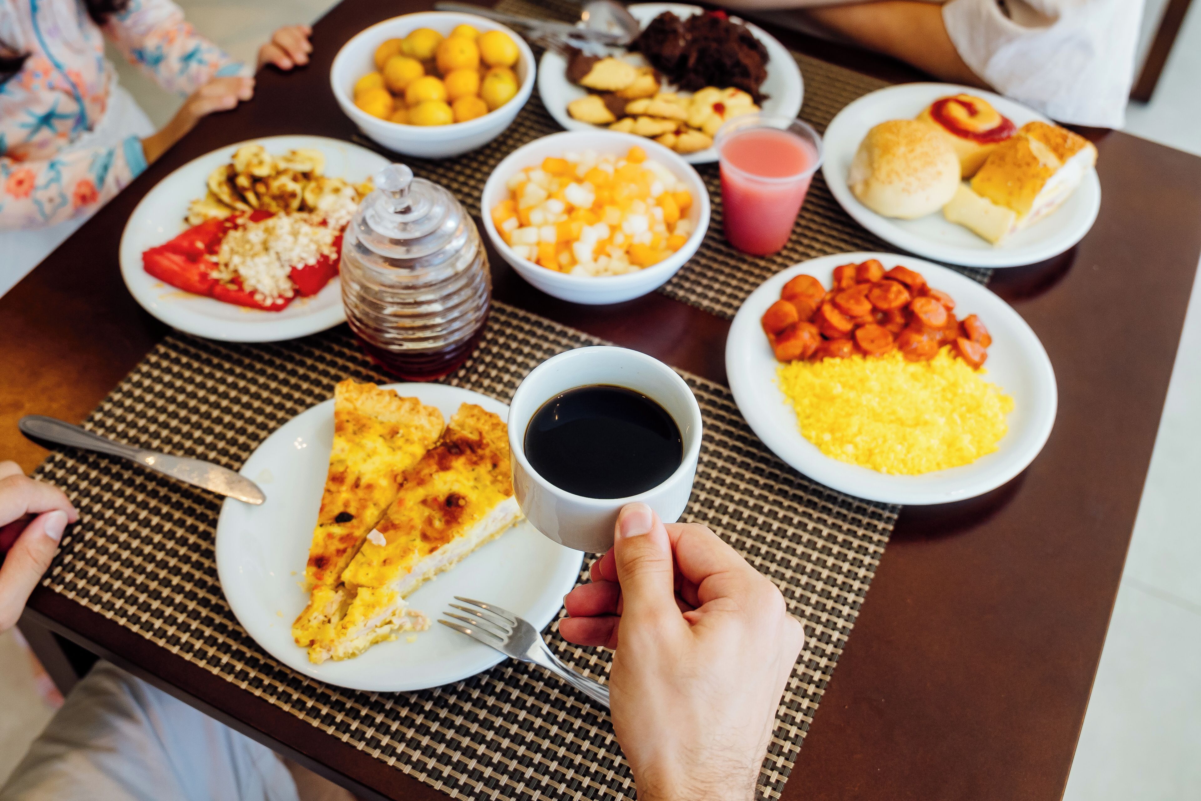 Uma mesa com diversos pratos, incluindo pizza, uma xícara de café e uma garrafa de água.
