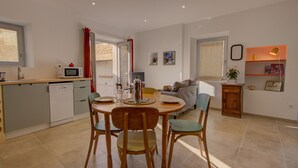 Una cocina moderna con comedor, un sofá y una pequeña mesa con sillas.