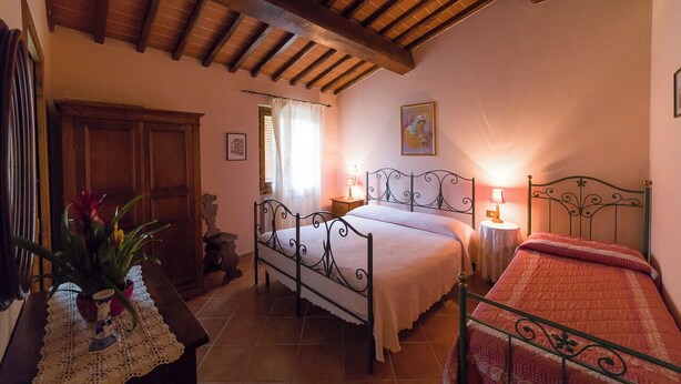 A bedroom with a bed, bedside table, lamp, and a potted plant. - Apartment in the heart of Tuscan nature. Pets allowed (Castelfranco Piandiscó)