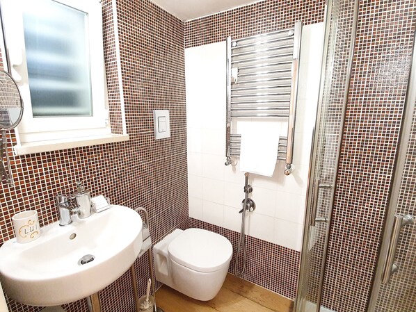 A bathroom with a white sink, toilet, and shower. - Garden House (Bari)
