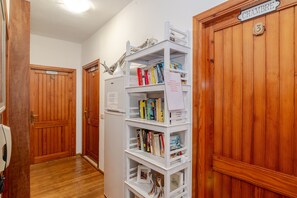 Un pasillo con puertas de madera, una estantería blanca y un cartel que indica el número 3.