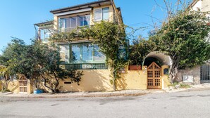 A two-story building with a balcony, a small garden, and a gate. - Room 'La Chicca Di Francesca- Room 3' with Private Terrace, Wi-Fi and Air Conditioning (Santa Teresa Gallura)