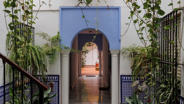 A corridor with a blue archway, columns, and potted plants. - 'Juderia Center Premium Suites Free Parking' Apartment with Balcony, Wi-Fi & Air Conditioning (Seville)