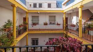 A multi-level building with balconies, railings, and potted plants. - 'Juderia Center Premium Suites Free Parking' Apartment with Balcony, Wi-Fi & Air Conditioning (Seville)