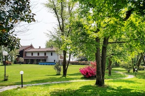 Una propietat residencial amb un jardí ben cuidat, un camí i una casa amb teulada aural.