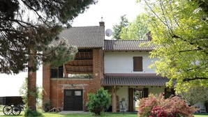 A two-story building with a brick facade, a satellite dish, and a small porch area. - Apartment Casa 'Bianca' with Wi-Fi and Air Conditioning (Novara)