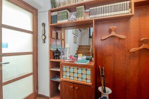 Ein Holzinnenraum mit Bücherregal, Spiegel und einer Tür mit satinierten Glasscheiben.