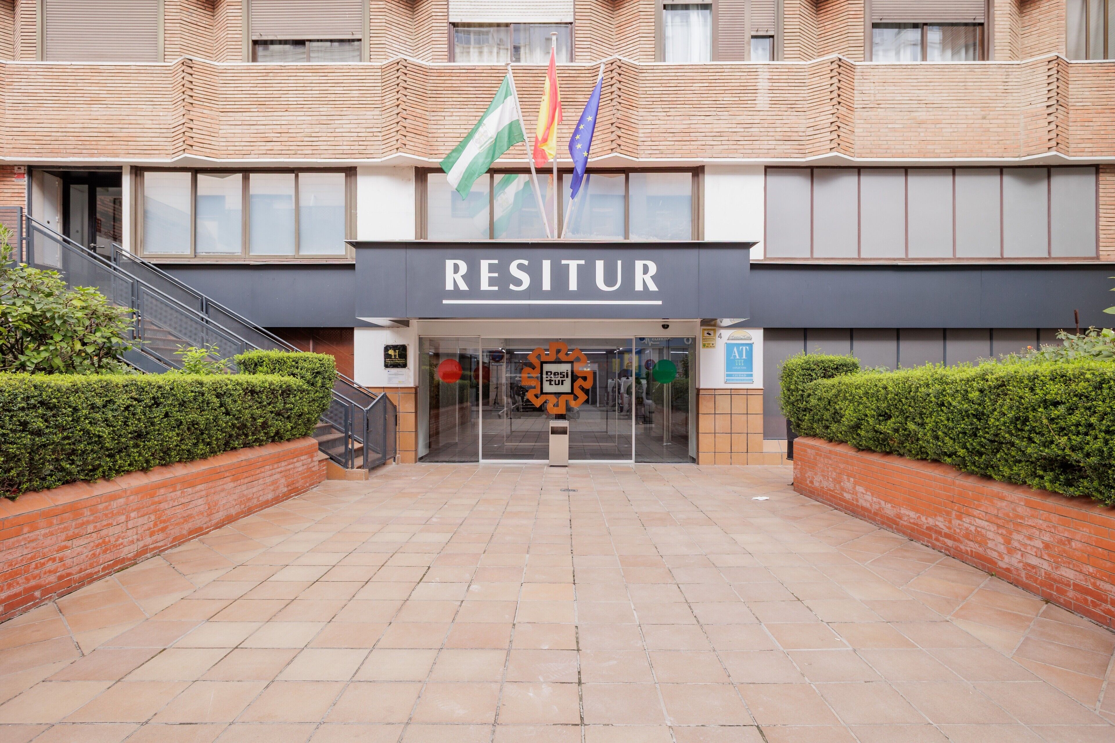 A building with a sign reading 'RESITUR' and multiple flags.