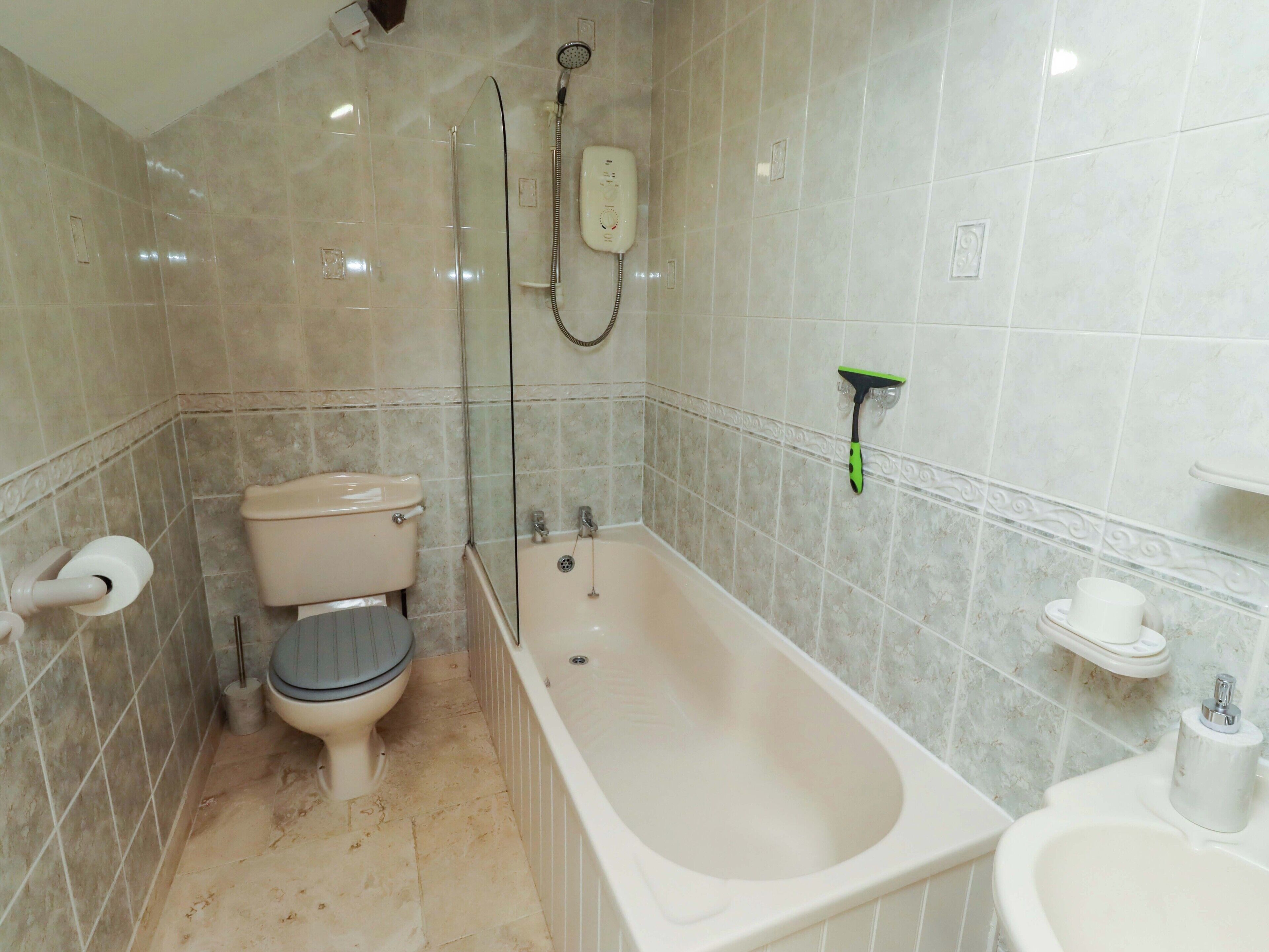 Un baño con inodoro, bañera y ducha.