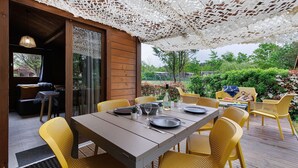An outdoor dining area with a table set for two, surrounded by yellow chairs, under a white lace canopy. - Chalet “Prestige Le 13” with Shared Pool, Communal Garden and Wi-Fi (Saint-Gervais)