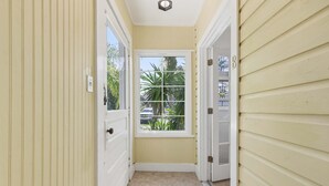 A narrow hallway with a window, a door, and a doorbell. - The Pearl, 2 Unit Stay for 10 (St. Augustine)