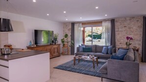 Un salon moderne avec un canapé, une table basse et un téléviseur.